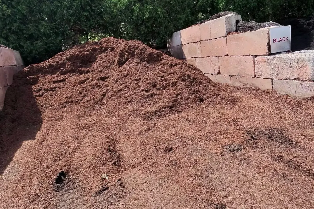 Bulk brown mulch pile between block bins at the A.Z. Landscape Supply yard in Tabernacle, NJ
